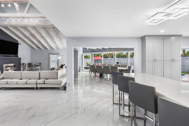 living area featuring marble finish floor, beamed ceiling, and recessed lighting