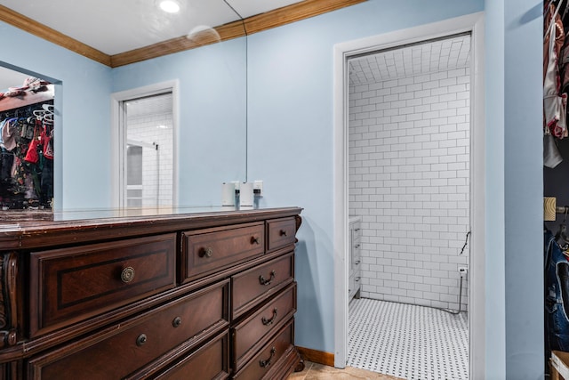 bathroom featuring tiled shower, a walk in closet, crown molding, and vanity