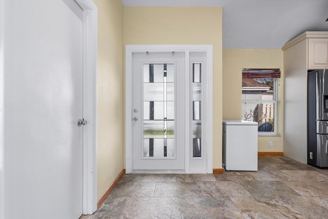 doorway with stone finish flooring and baseboards