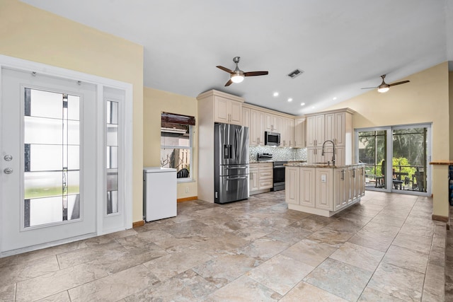 kitchen featuring cream cabinetry, lofted ceiling, visible vents, appliances with stainless steel finishes, and a sink