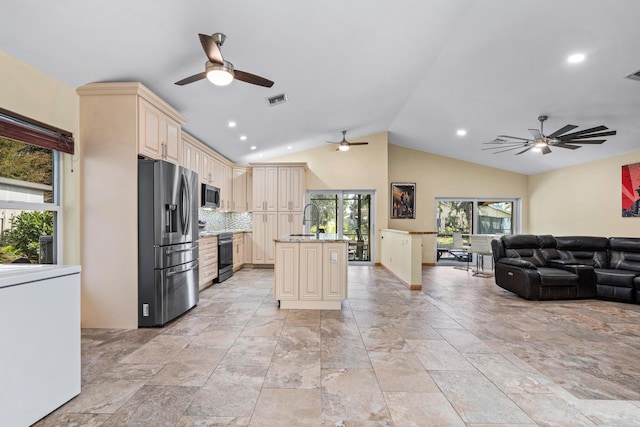 kitchen with visible vents, cream cabinets, appliances with stainless steel finishes, open floor plan, and a sink