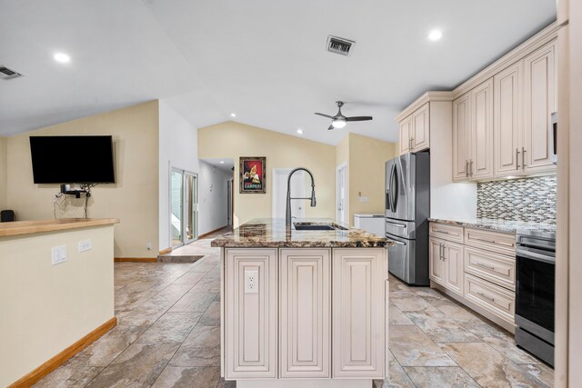 kitchen with lofted ceiling, visible vents, cream cabinets, appliances with stainless steel finishes, and a sink