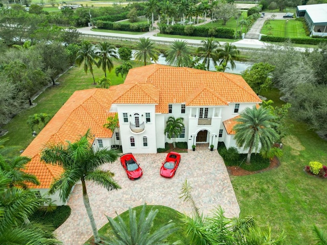 exterior space with a tiled roof, a front lawn, and stucco siding