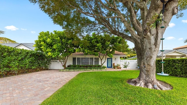 view of front facade with a front lawn, fence, and a gate