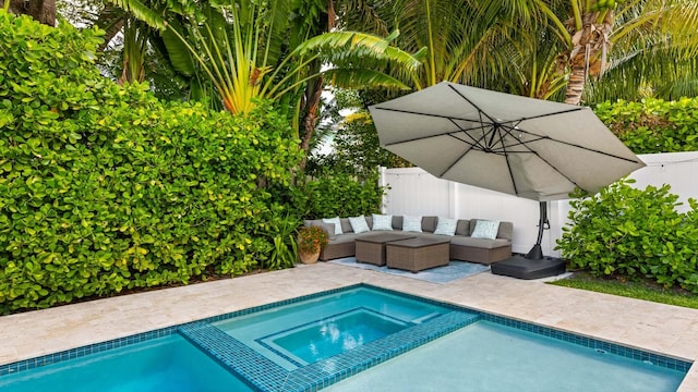 view of swimming pool with a pool with connected hot tub, a patio area, fence, and an outdoor living space