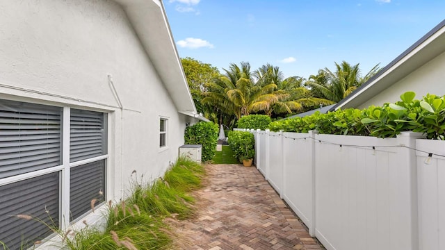 view of property exterior featuring a patio area, fence, and stucco siding