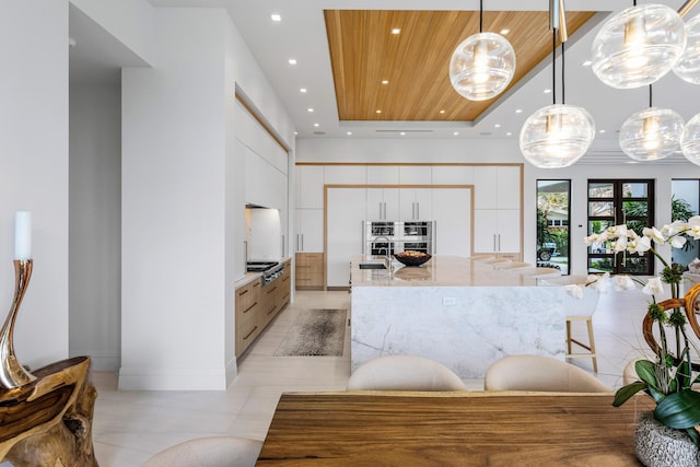 kitchen featuring stainless steel gas cooktop, white cabinets, a sink, modern cabinets, and wooden ceiling