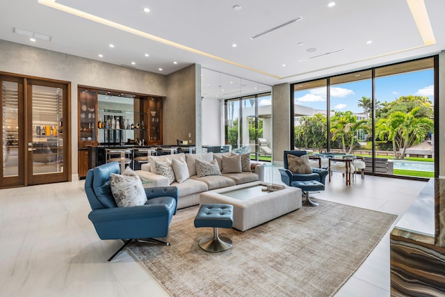 living room with expansive windows, visible vents, a tray ceiling, and recessed lighting