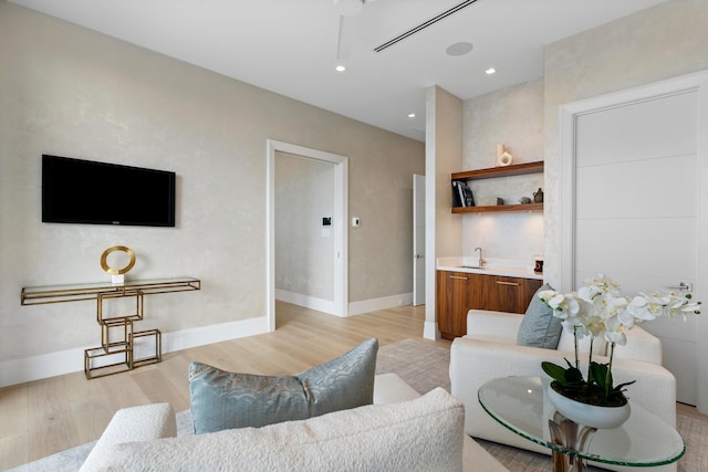 living area featuring recessed lighting, light wood-style flooring, and baseboards