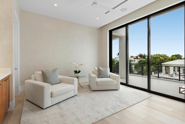 living area featuring light wood finished floors, ceiling fan, baseboards, and recessed lighting