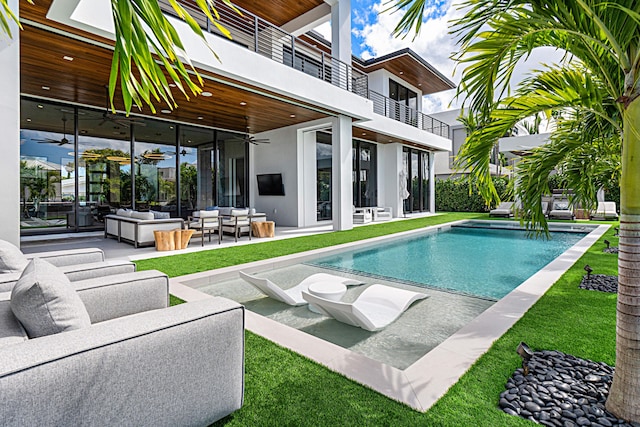 outdoor pool with ceiling fan, a patio area, a lawn, and outdoor lounge area