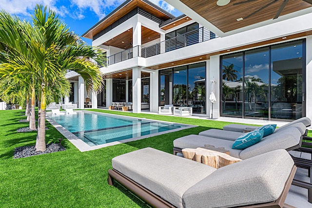 outdoor pool with a patio area, a yard, and an outdoor hangout area