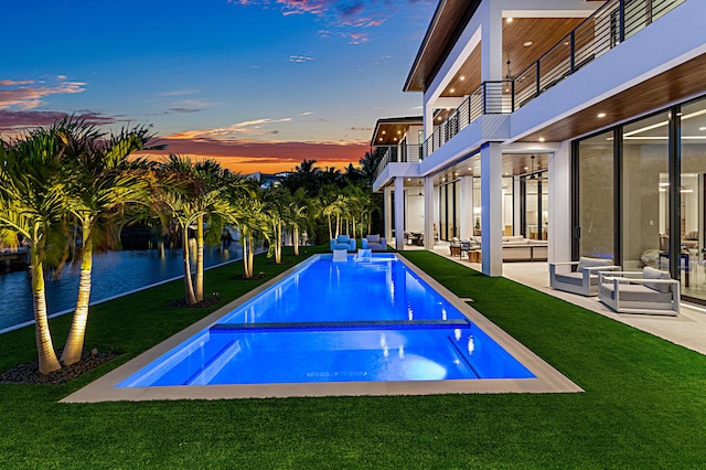 pool featuring a patio area, an outdoor hangout area, and a lawn