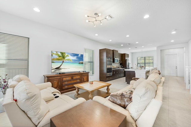 living room with light tile patterned floors, visible vents, and recessed lighting