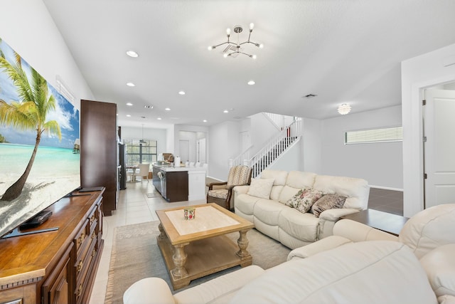 living area with recessed lighting, stairway, an inviting chandelier, and light tile patterned flooring