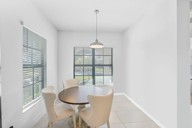 dining area with light tile patterned floors, plenty of natural light, and baseboards