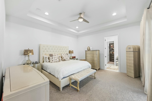 bedroom with recessed lighting, a raised ceiling, and light colored carpet