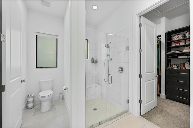 full bathroom featuring a walk in closet, visible vents, toilet, a shower stall, and baseboards