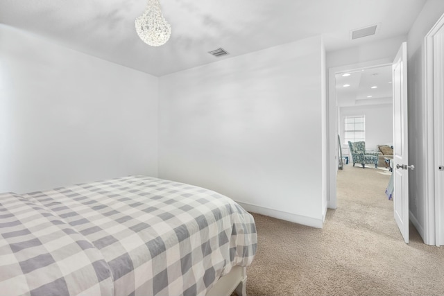 bedroom featuring an inviting chandelier, light colored carpet, visible vents, and baseboards