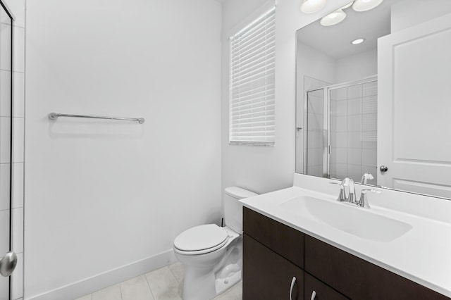 bathroom featuring tile patterned flooring, baseboards, toilet, tiled shower, and vanity