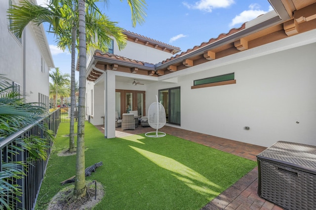 view of yard with ceiling fan, french doors, a patio, and a fenced backyard