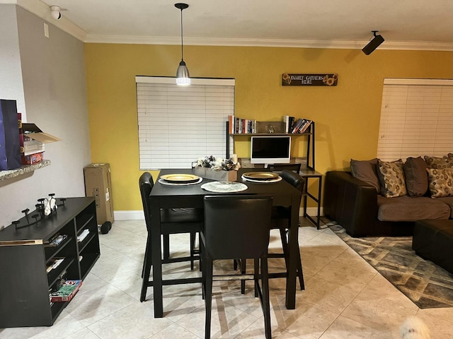 tiled dining space featuring ornamental molding and baseboards