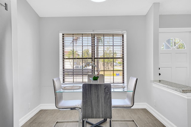 dining space featuring a wealth of natural light, baseboards, and wood finished floors