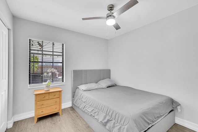 bedroom featuring a ceiling fan, baseboards, and wood finished floors