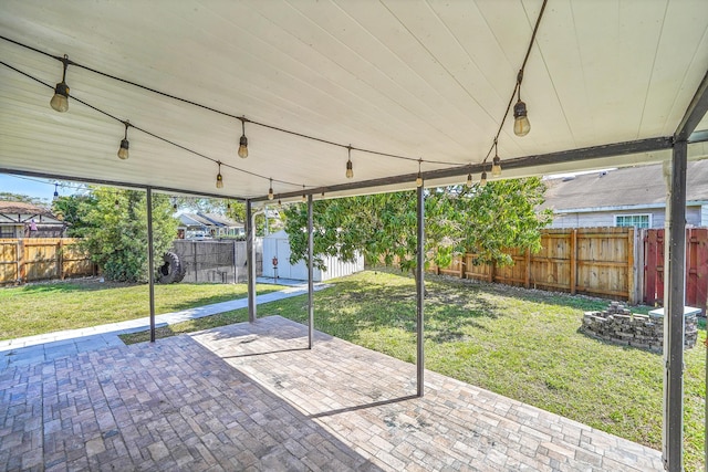 view of patio with a fenced backyard, a shed, and an outbuilding