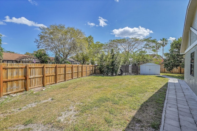 view of yard with an outbuilding, a shed, and a fenced backyard