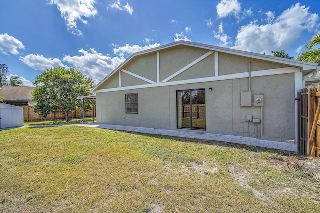 back of property featuring stucco siding, fence, a patio, and a yard