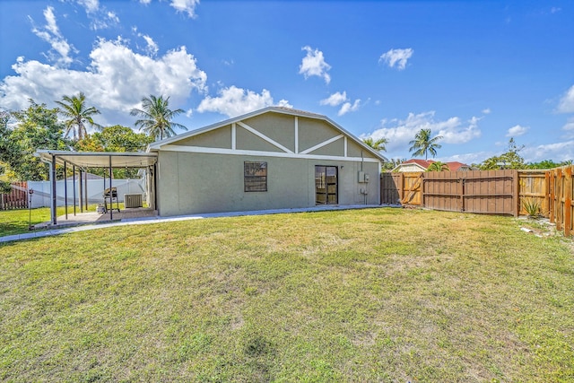 rear view of property featuring stucco siding, a fenced backyard, a lawn, and a patio