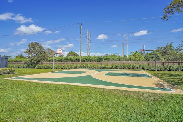 view of sport court featuring a yard, fence, and community basketball court