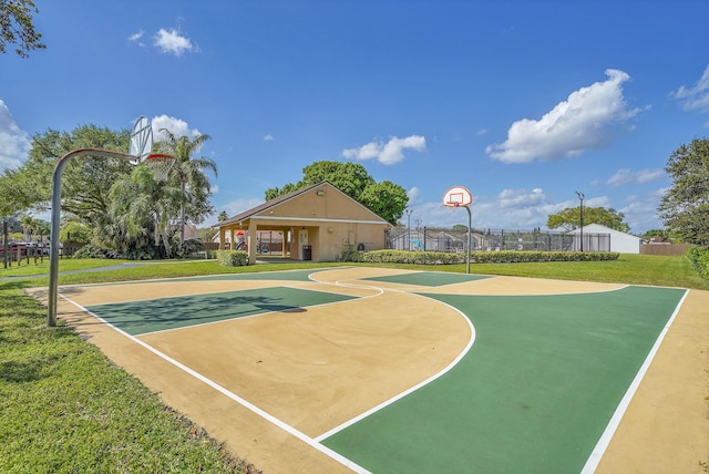 view of sport court featuring community basketball court, fence, and a lawn