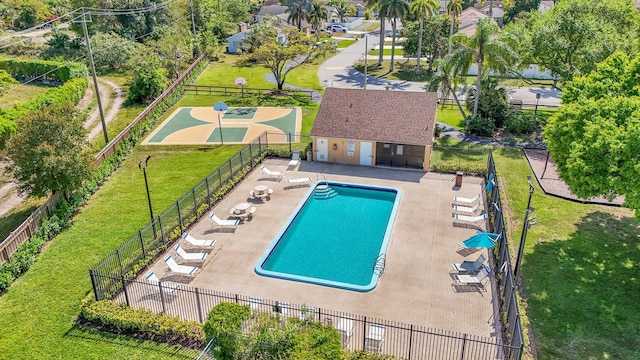 community pool with a patio, a yard, and fence