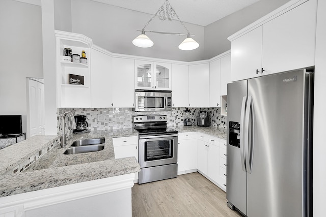 kitchen with a sink, light wood-style floors, appliances with stainless steel finishes, backsplash, and open shelves