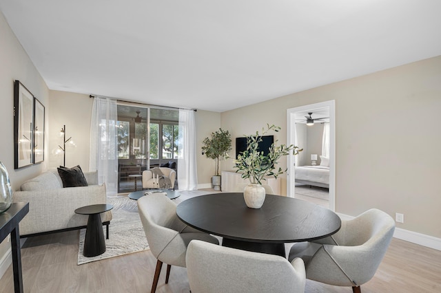 dining space with light wood-style flooring and baseboards