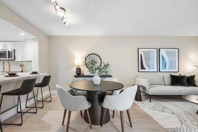 dining space with recessed lighting, light wood-type flooring, and baseboards