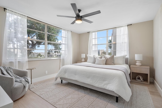 bedroom featuring baseboards, a ceiling fan, and light wood-style floors