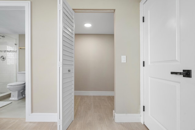 hallway featuring light wood-type flooring and baseboards