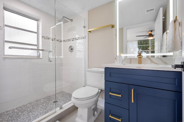 bathroom with visible vents, toilet, a ceiling fan, a stall shower, and vanity