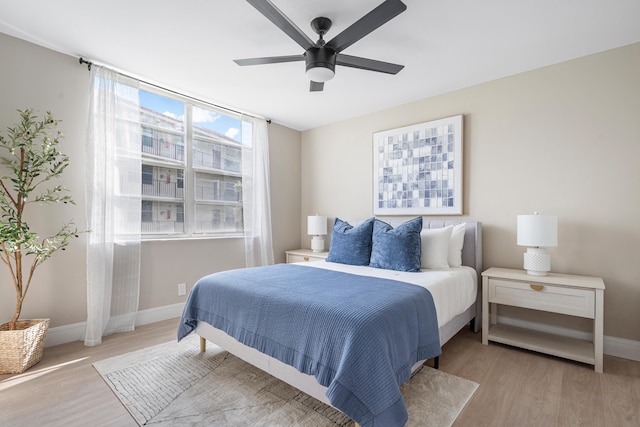 bedroom featuring a ceiling fan, baseboards, and wood finished floors