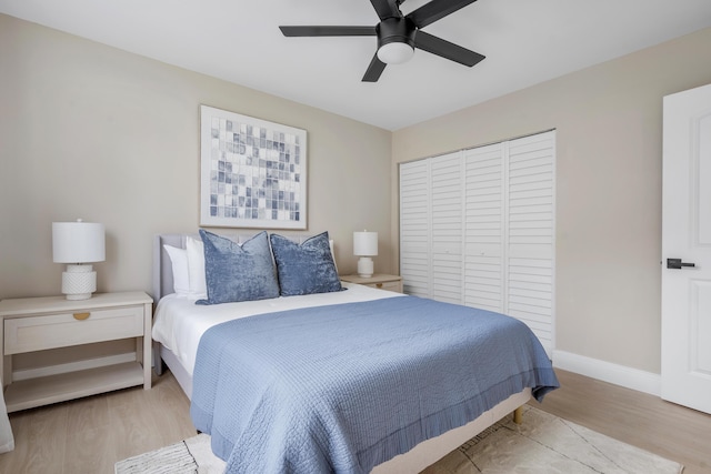 bedroom with ceiling fan, a closet, baseboards, and wood finished floors