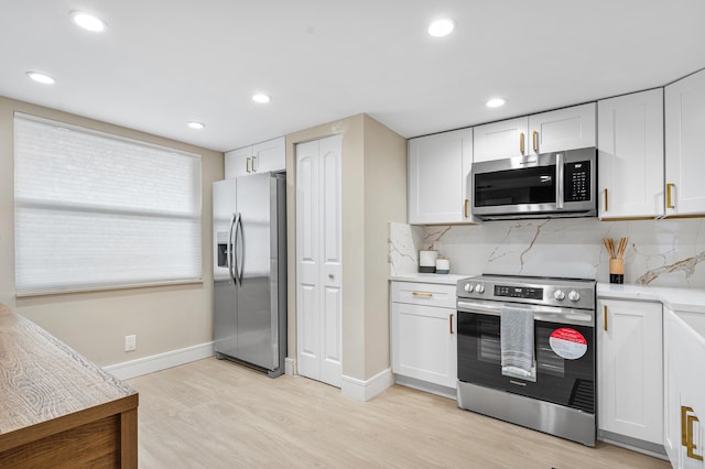 kitchen featuring light wood-style floors, white cabinetry, stainless steel appliances, and light countertops