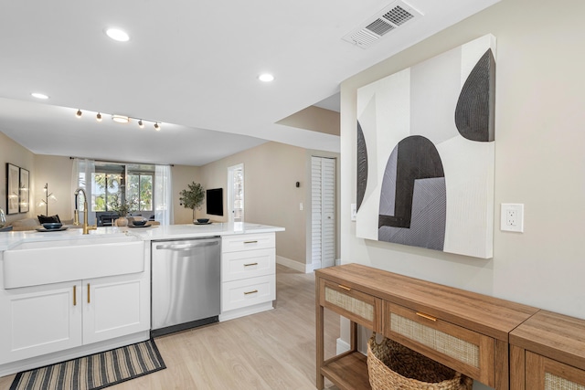 kitchen with a sink, visible vents, light wood-style floors, open floor plan, and dishwasher