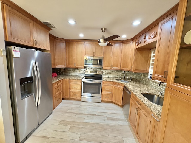 kitchen with light stone countertops, visible vents, appliances with stainless steel finishes, and a sink