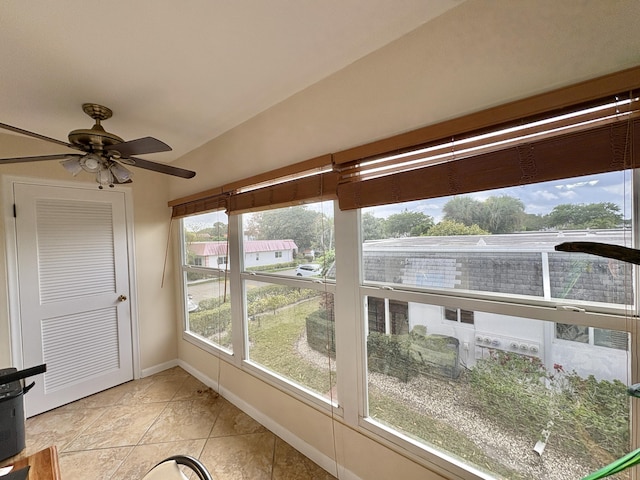 unfurnished sunroom with lofted ceiling and a ceiling fan