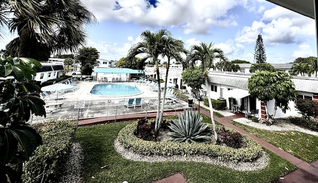 community pool with a patio area and fence