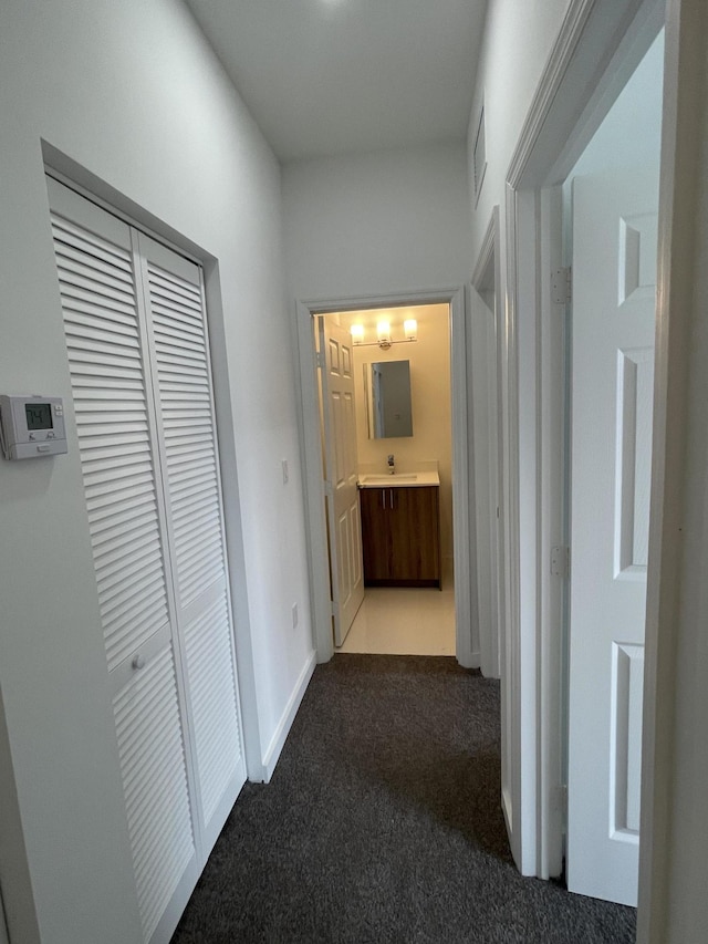 corridor featuring visible vents, baseboards, and carpet flooring