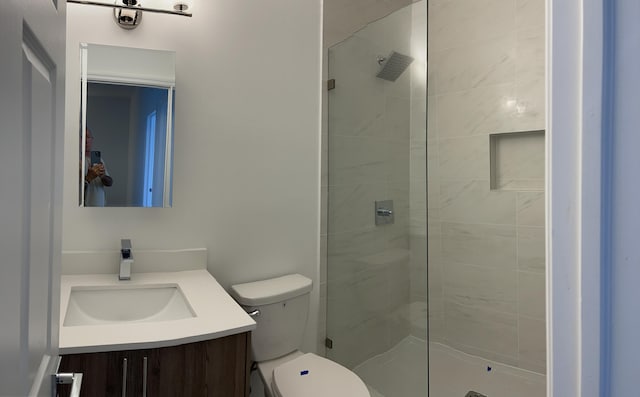 full bathroom featuring vanity, a shower stall, and toilet